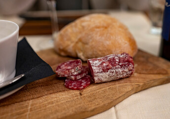 Tasting of homemade dried salami sausages in butchery shop in Parma, emilia Romagna, Italy