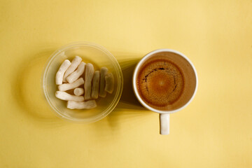 bowl of salty snack and empty cup of coffee with yellow background