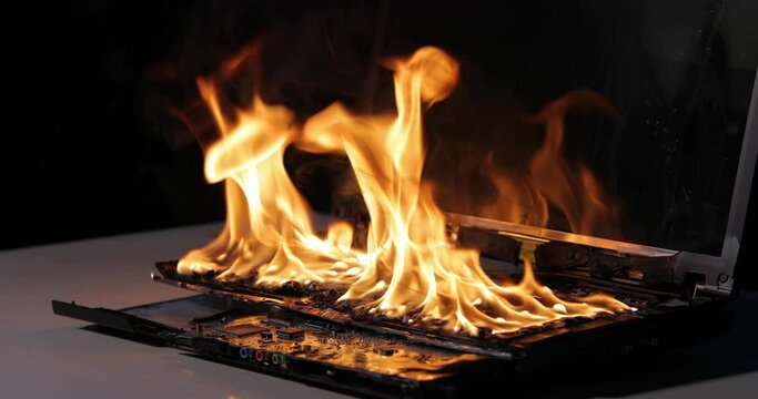 Burning laptop computer electronics closeup