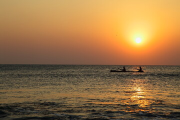 A beautiful sunrise seascape view with fisherman and fishing boats.