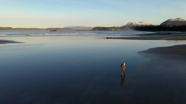 A Woman Walking Alone On A Beach In The Morning