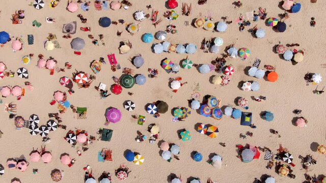 Rio de Janeiro, Brazil, top down aerial view of famous Copacabana Beach showing colourful sun umbrellas and people relaxing on a summer day.