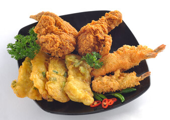 Delicious crispy fried chicken, fried shrimp and tempe mendoan in the black plate 