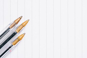 Close up shot of old ballpoint pens on a lined sheet of paper