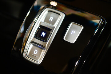 Modern gearbox control button on a central console in a new car