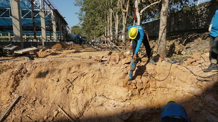 Workers are drilling at a construction site.