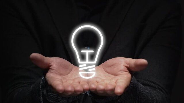 idea concept. a business man hands shows hologram of electronic light bulb.