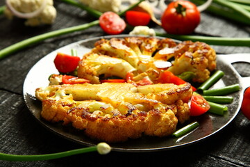 Delicious roasted vegetables- cauliflower, tomatoes, green beans, onions, healthy vegan diet appetizer.