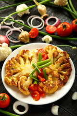 Homemade grilled cauliflower  and organic  vegetables. tomatoes, green beans onions, healthy vegan diet meal.