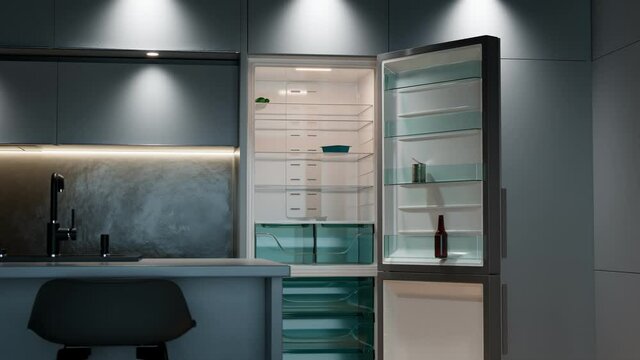 Modern kitchen refrigerator slowly opens revealing empty shelves with no food