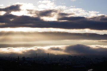 Iida, Nagano, Japan, 2021-11-10 , Clouds lighted by the sun during sunrise in early morning over Iida city, in Nagano, Japan.