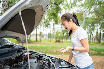 Women spection. She opened the hood Broken car on the side See engines that are damaged or not.