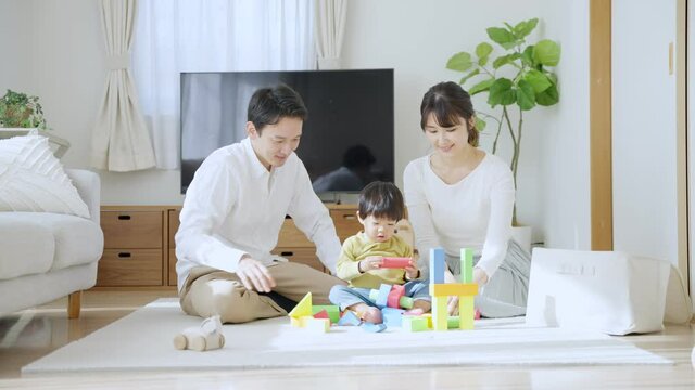 60p　積み木で子供と遊ぶ両親（育児・子育て・家族・ファミリー）