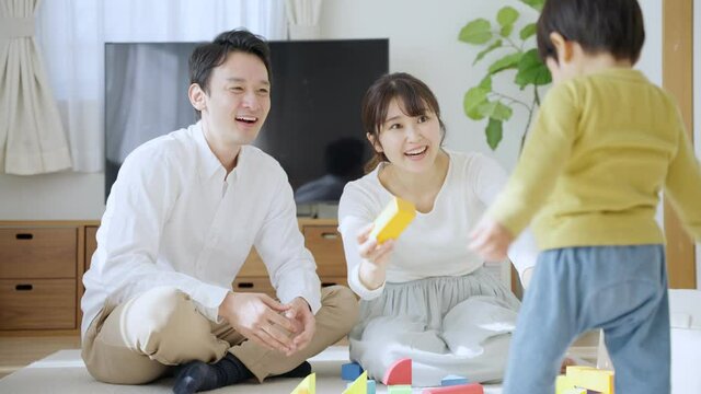 60p　積み木で子供と遊ぶ両親（育児・子育て・家族・ファミリー）