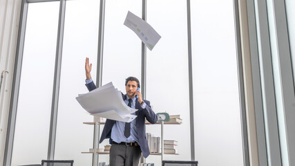 Male business manager throws paper and document to the air to express his emotion after getting...