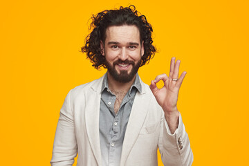 Smiling man showing OK sign in studio