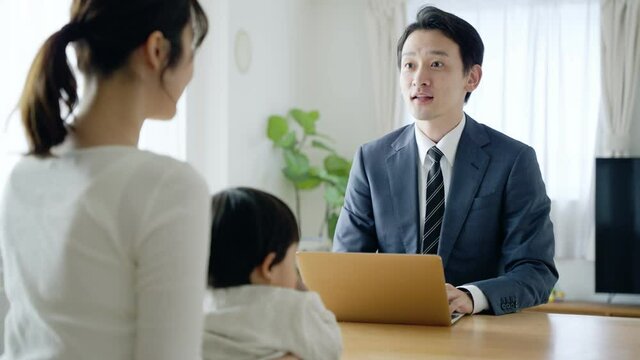 60p　パソコンを使って営業するビジネスマンと母子
