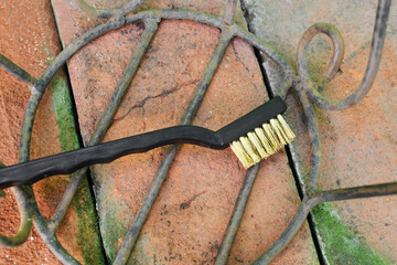 Cepillo de alambre utilizado para reparar base de maceta oxidada.