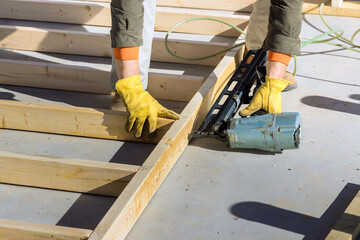 A carpenter for nailing wooden beam using an air hammer