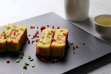 Egg roll made with paprika and bell peppers. Alcohol and rolled omelet.
