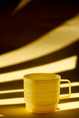 yellow plastic cup with light and shadow as background