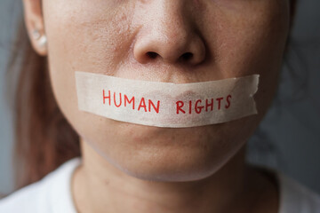 woman with mouth sealed in adhesive tape with Human rights message. Free of speech, freedom of...