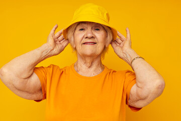 Photo of retired old lady happy lifestyle in a yellow headdress yellow background