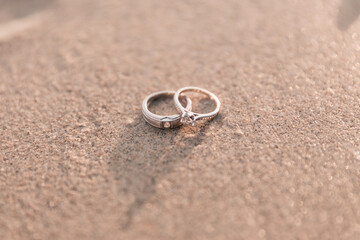 Two silver wedding rings on the beach