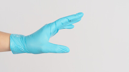 Hand do touching gesture and wear blue medical glove on white background.