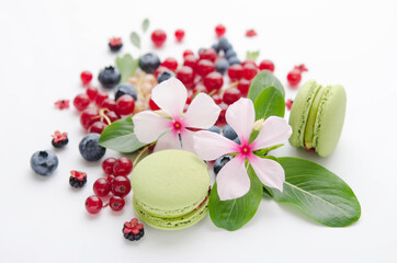A scattering of juicy berries, flowers and macarons.