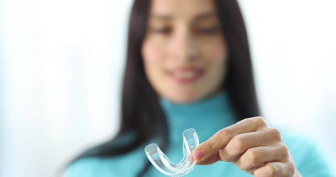 Woman holding plastic night guard for teeth closeup 4k movie slow motion