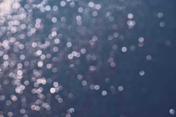 Festive Blue background of silver glitter lights. Winter blurred abstraction