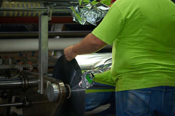 Flexo Packaging printing machine being fed with metallic rolling drum.