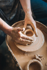 Clay modeling hands on a potter's wheel. Handmade. Ceramic tableware.