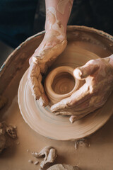Clay modeling hands on a potter's wheel. Handmade. Ceramic tableware.