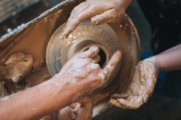 Clay modeling hands on a potter's wheel. Handmade. Ceramic tableware.