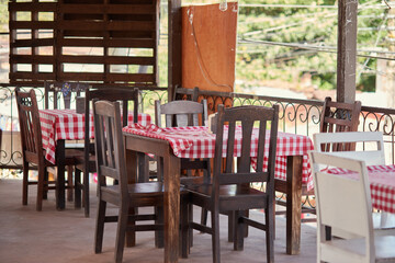 table and chairs with checkered table cloths in a restaurant in a small town