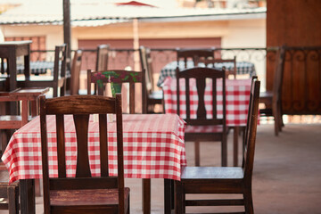 table and chairs with checkered table cloths in a restaurant in a small town