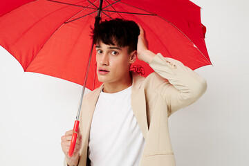 handsome guy holding an umbrella in the hands of posing fashion light background unaltered