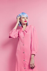 glamorous woman wears a blue wig makeup pink background