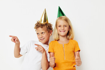 Boy and girl posing emotions holiday colorful caps isolated background unaltered