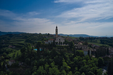 Fototapeta na wymiar Parish Church of Saints Fermo and Rustico, on a hill in the province of Verona, Colognola Ai Colli, Italy. Catholic church on a hill surrounded by vineyards. Italian historic town on a hill.