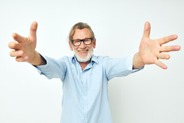 old man in blue shirts gestures with his hands isolated background