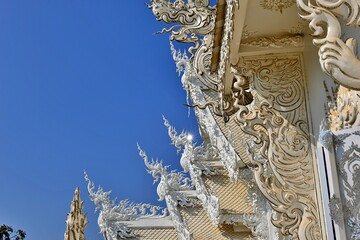 Fototapeta na wymiar Wat Rong Khun OR White temple with blue sky background. ChiangRai province, Thailand.