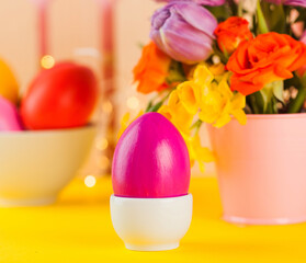 Fototapeta na wymiar Easter card. Colorful Easter eggs on the background of a bouquet of flowers.