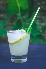 glass of lemonade with mint and ice on a black table
