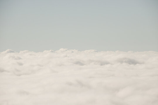 Scenery seen from airplane above the white clouds in the sky
