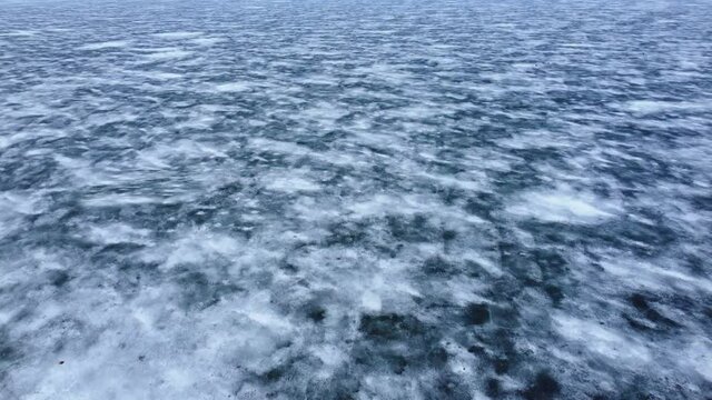 Top view of the endless water surface, covered with ice and snow. Beautiful view of the northern arctic nature. Global warming and climate change the concept of melting ice. High quality 4k footage