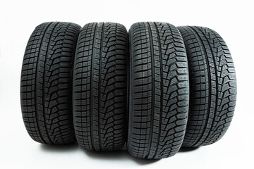 Winter tires rolling forward isolated on white background. Set of four wheel for use in snow and on...