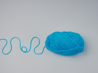 Colorful wool balls on a white background. The balls of wool are partially unfolded.